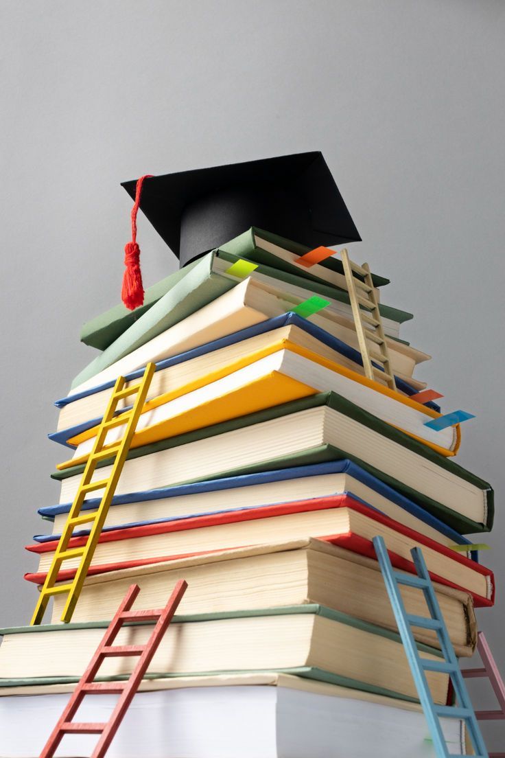 free photo low angle of stacked books, a graduation cap and ladders for educ
